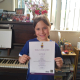 Valentina getting a Distinction for her singing exam -2025.